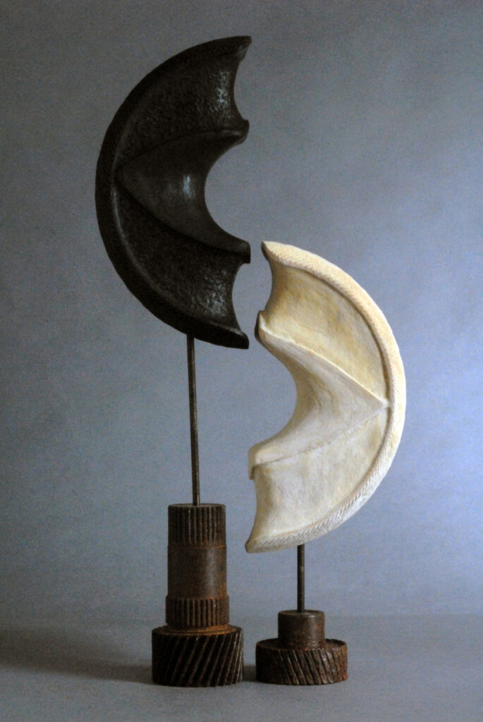 A black and white moon-shapped sculpture placed on the floor.