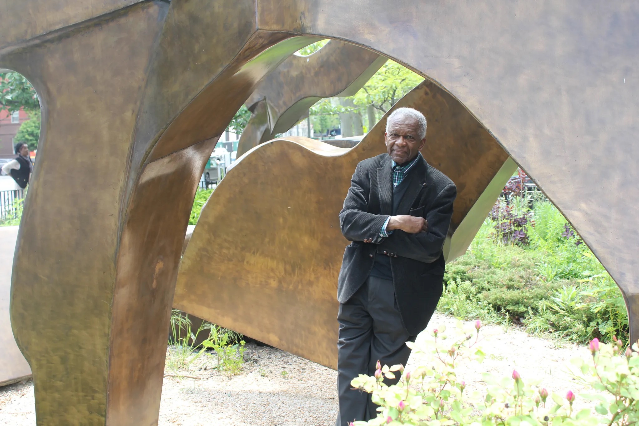 Sculptor Richard Hunt leaning against his sculpture.